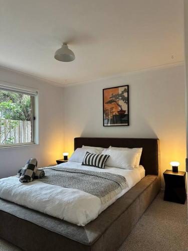 a bedroom with a large bed with two lamps at Senja in Torquay