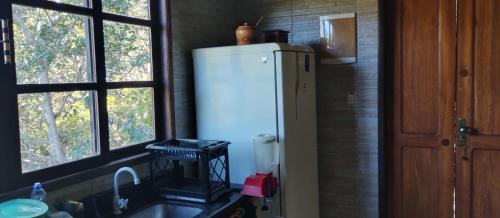 uma cozinha com um frigorífico branco ao lado de uma janela em Espaço Gaia em Palmeiras