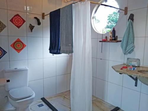 um banheiro com vaso sanitário e cortina de chuveiro em Espaço Gaia em Palmeiras