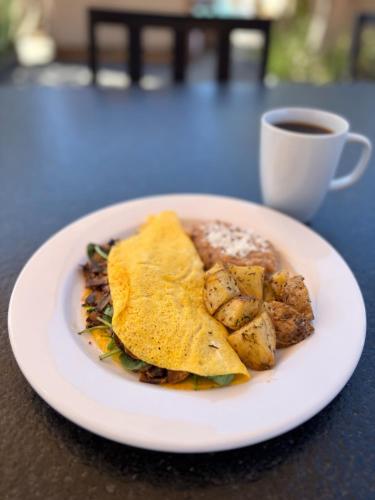 een bord eten op een tafel met een kopje koffie bij Hotel Flores de Sal-Valle de Guadalupe in Valle de Guadalupe