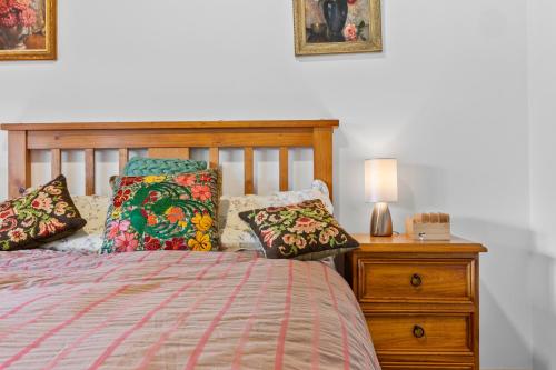 a bedroom with a bed and a dresser with a lamp at Maureens Retreat in Eureka