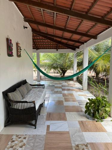 eine Terrasse mit einer Couch und einer Hängematte in der Unterkunft Summer House in Jijoca de Jericoacoara