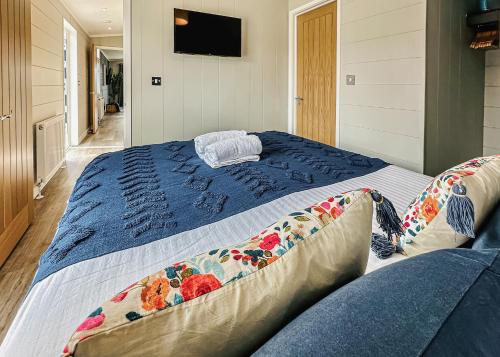 Un dormitorio con una cama grande con sábanas azules. en Croft Farm Water Park, en Tewkesbury