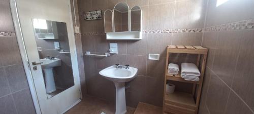 un piccolo bagno con lavandino e specchio di La Nona a General Belgrano
