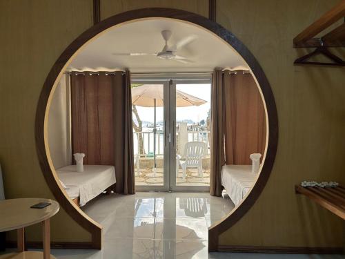 an oval mirror in a living room with a bedroom at El Nido, Corong Corong Pier in El Nido