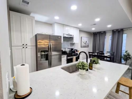 een keuken met een roestvrijstalen koelkast en witte kasten bij Private Master Bedroom North Lamar in Austin