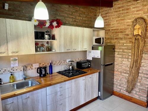 a kitchen with a stainless steel refrigerator and a sink at One Cabañas 2 in Los Antiguos