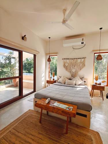 a bedroom with a large bed and a table at Tuscan Breeze, Nandi Hills in Nandigunda