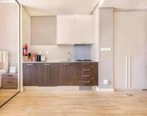 una cucina con mobili bianchi e pavimento in legno di Luxurious cozy studio a Dubai