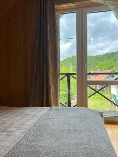 a bedroom with a bed and a large window at Заворіття in Sheshory