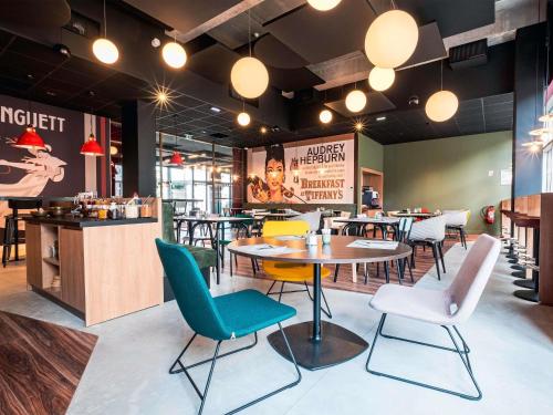 un restaurante con sillas, una mesa y una barra en ibis Styles Lens Centre Gare, en Lens