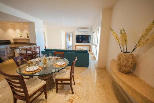 a dining room and living room with a table and chairs at Hotel Tres Vidas Acapulco in Barra Vieja