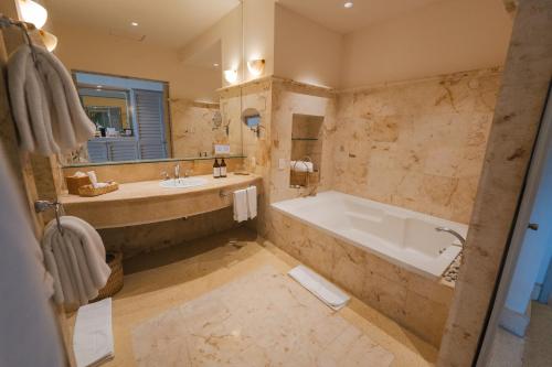 a large bathroom with a tub and a sink at Hotel Tres Vidas Acapulco in Barra Vieja