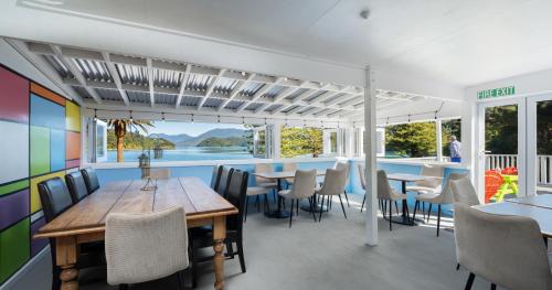 Portage Bay Hub في Portage: غرفة طعام مع طاولات وكراسي وحمام سباحة