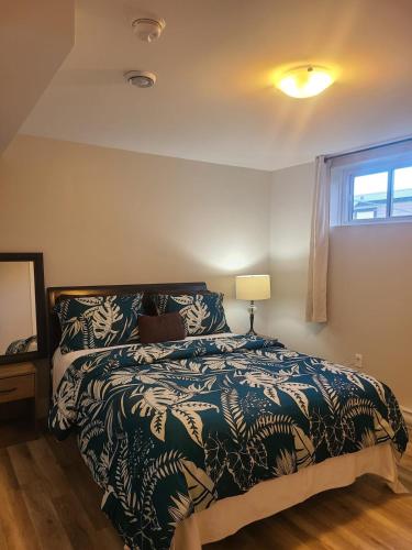 a bedroom with a bed and a lamp and a window at Private One Bedroom Basement Apartment with Separate Entrance in Dieppe