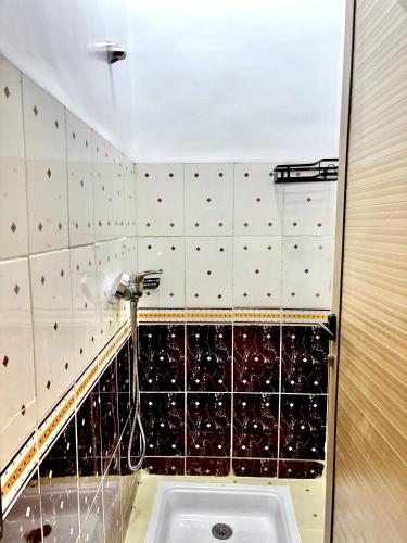 een badkamer met een wastafel en zwarte en witte tegels bij Zyarat Marrakech in Marrakesh