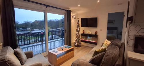 a living room with a large window with a balcony at Chalet 176 Glan Gwna Park Caernarfon in Caeathro