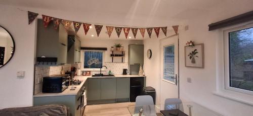 a kitchen with a table and a kitchen with flags on the wall at Chalet 176 Glan Gwna Park Caernarfon in Caeathro