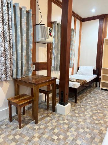 Sequor Palm Villa - Main Building في سيكويجور: غرفة صغيرة بها سرير وطاولة وسرير وسرير