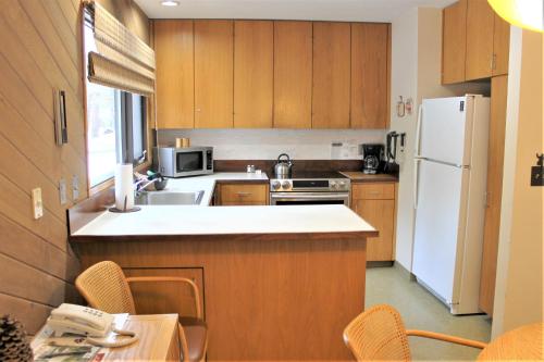 una cucina con mobili in legno e un frigorifero bianco di Meadow House 58 a Sunriver