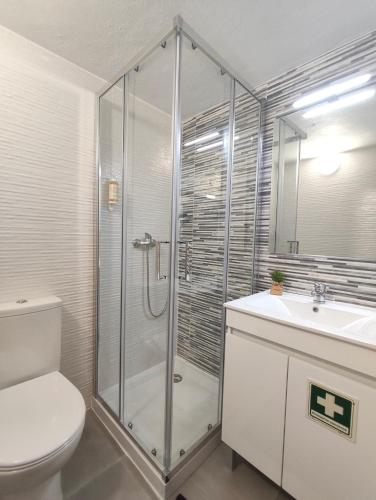 a bathroom with a shower and a toilet and a sink at Misericórdia Rooms in Guarda