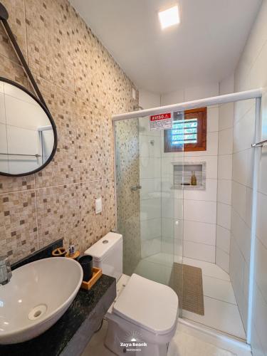 a bathroom with a shower and a toilet and a sink at Zaya Beach Residence in Icaraí