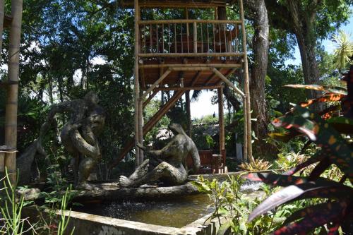 three statues sitting in a fountain in a garden at Los Alpes in Ibagué