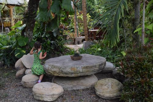 a doll sitting on a stone table in a garden at Los Alpes in Ibagué