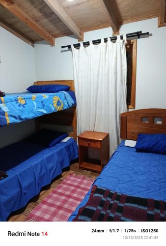 um quarto com dois beliches e uma mesa em La Morada del Colibrí em El Tabo