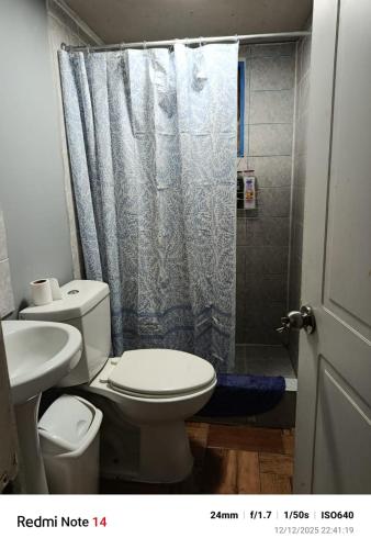 um banheiro com vaso sanitário e chuveiro em La Morada del Colibrí em El Tabo