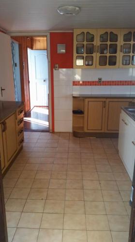 a kitchen with a tiled floor and a large room at El Quisco vista hermosa in El Quisco