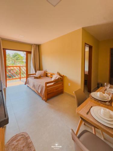 a bedroom with a bed and a table with a dining room at Zaya Beach Residence in Icaraí