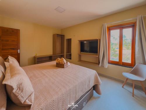 una camera da letto con un letto, una finestra e una televisione di Zaya Beach Residence a Icaraí