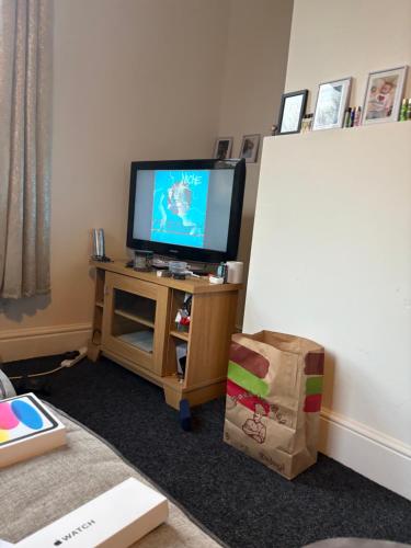 a living room with a television on a table with a box at Nice flat tv and WiFi town centre in Hull
