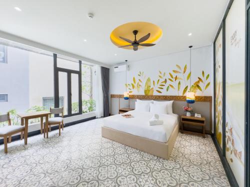 ein Hotelzimmer mit einem Bett und einem Tisch in der Unterkunft Sujet Center Hotel by Haviland in Đà Nẵng