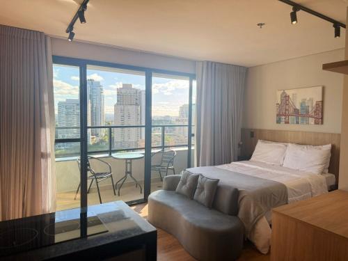 una camera da letto con un letto, un divano e un balcone di Bexpspces Sky Design Alphaville a Aldeia