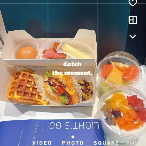a box of food with a sandwich and waffles and fruit at Atour Light Hotel Shanghai Minhang Maqiao in Shanghai