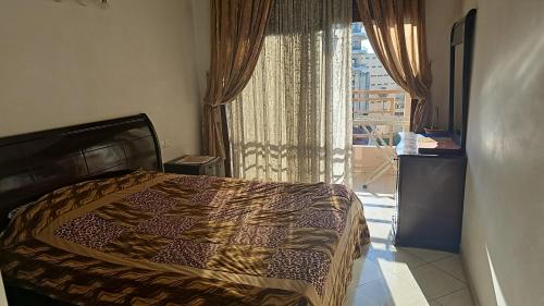 Un dormitorio con una cama y una ventana grande. en Apartment Hamria Meknes, en Meknès