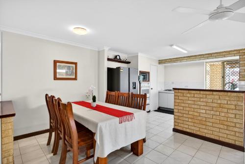 een keuken en eetkamer met een tafel en stoelen bij Spacious 4-Bed House with Private Garage in Coodanup
