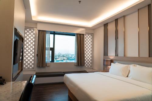 a bedroom with a large bed and a large window at lee hotel lat phrao in Bangkok