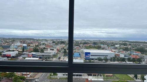 a view of a city from a window at Apartamento Novo in Capão da Canoa