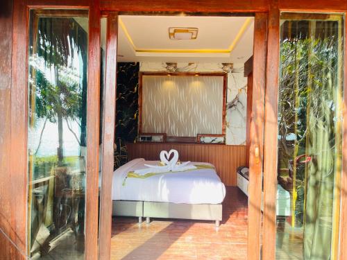 een slaapkamer met een bed en een glazen deur bij New Ozone Resort & Spa in Koh Lanta