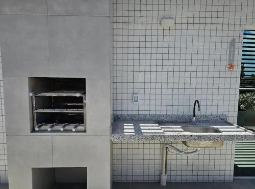 a kitchen with a sink and a counter top at Estúdio a 1 min do mar - Mila rooftop in Tamandaré