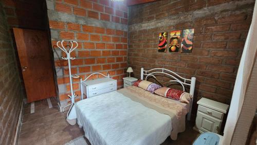 a bedroom with a bed and a brick wall at La Hueya in Coronel Moldes