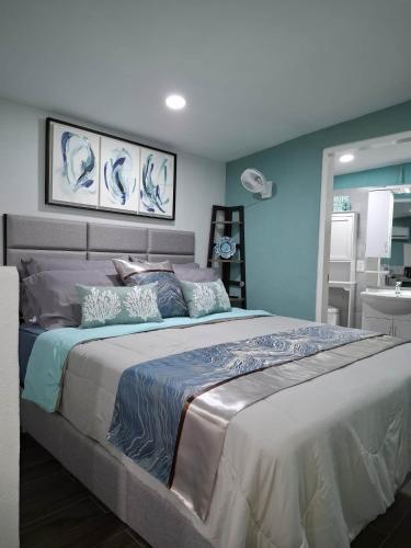 a bedroom with a large bed with blue walls at Hidden Palms Inn Garden Deluxe in San Juan
