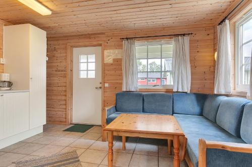 a living room with a blue couch and a table at Ballangen Camping in Narvik