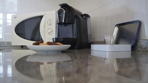 a coffee maker sitting on a counter with a plate of food at Alojamento Rural de Vales in Vales