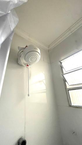 a room with a ceiling fan and a window at Meu Lar Fora de Casa in Jandira