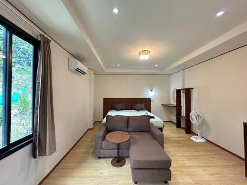 a hotel room with a bed and a couch and a table at Haad Salad Resort in Salad Beach