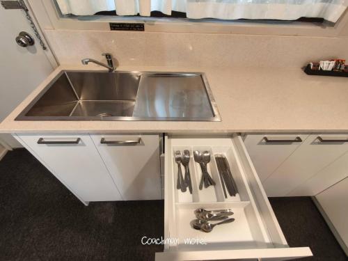 een keuken met een spoelbak en een aanrechtblad bij Coachman Motel and Holiday Units in Cowes